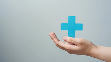 hand of a doctor holding a blue cross