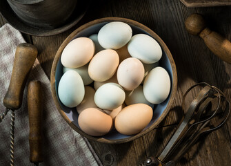 Bowl Full of Colorful Fresh Eggs on Wooden Table