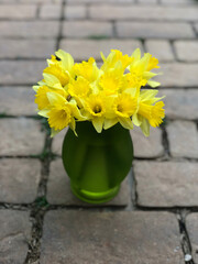 Yellow daffodil flowers in a green vase