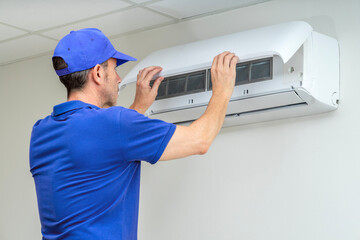 HVAC technician performing air conditioner maintenance inspection. Breakdowns repair service. Home...