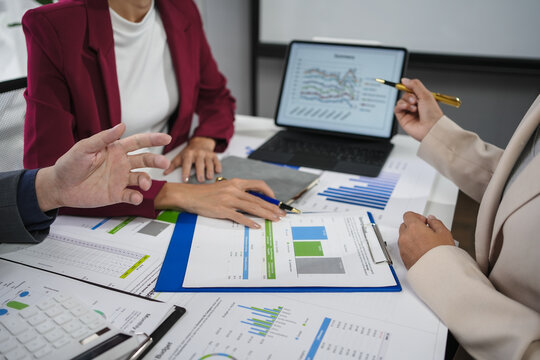 Businesspeople having a discussion about financial data displayed on a digital tablet and printed documents during a meeting
