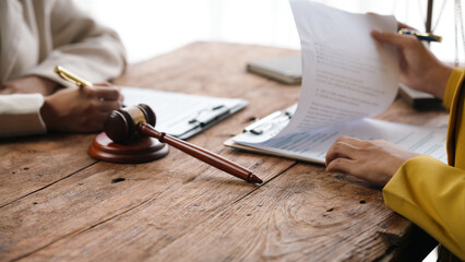 Two lawyers are discussing a legal case and reviewing a contract document before signing a...