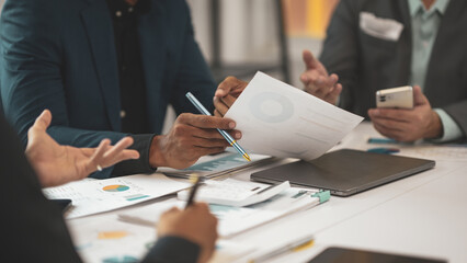 Business people in office analyzing financial data. Discussing strategy. Collaborating. Diverse team focused on teamwork and communication for company success. Modern setting with digital technology