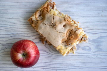 Piece of traditional thanksgiving apple cinnamon pie, apples and walnuts on the wooden cutting...