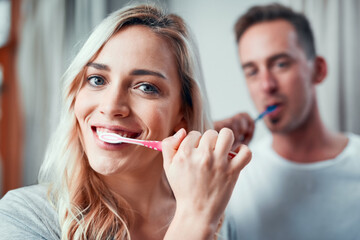 Portrait, dental and woman brush teeth with man in bathroom for oral hygiene, fresh breath or...
