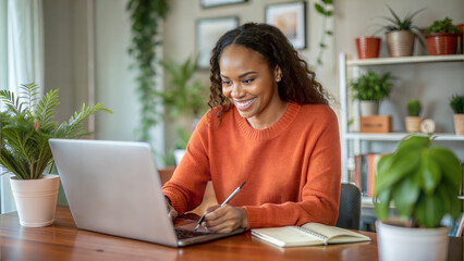 Fototapeta premium Portrait of smiling african american woman working on laptop at home