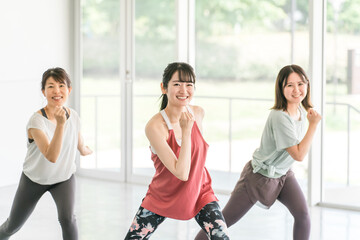 スポーツジムでダンス・エアロビレッスンをする女性達
