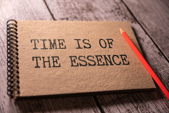 Closeup on businessman holding a card with TIME IS OF THE ESSENCE message