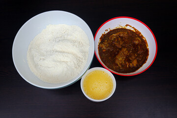 Preparation of Traditional Nigerian Masa with Spicy Stew and Batter Ingredients on Dark Wooden Table