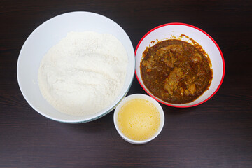 Preparation of Traditional Nigerian Masa with Spicy Stew and Batter Ingredients on Dark Wooden Table