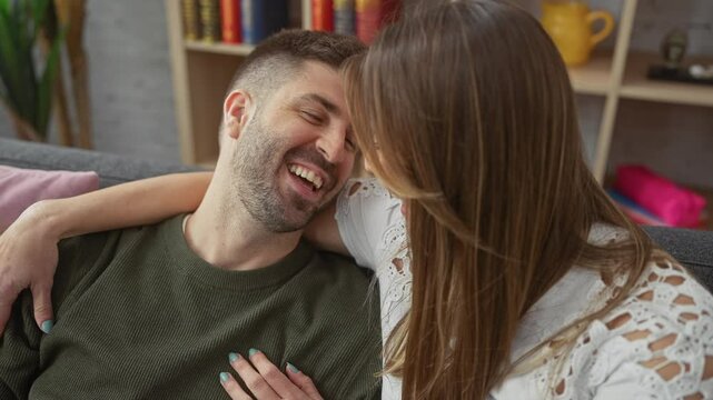 A loving couple shares a kiss, exuding happiness and affection indoors.