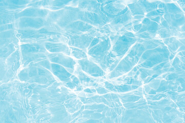 Obraz premium Blue water with ripples on the surface. Defocus blurred transparent blue colored clear calm water surface texture with splashes and bubbles. Water waves with shining pattern texture background.