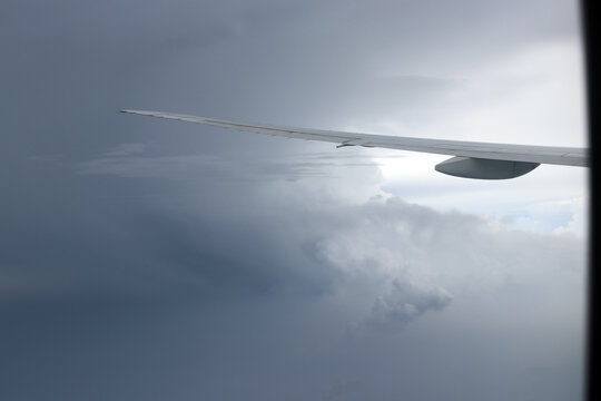 Aerial View of Urban Landscape with Airplane Wing Under Clear Blue Sky and Scattered Clouds