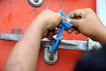 officers seal the container doors after the loading process is complete. Container security seal with code number to maintain goods security during shipping.