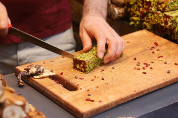 cutting Turkish traditional sweet Turkish delight on a chopping board 