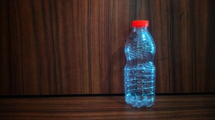 Empty plastic bottle isolated on wooden texture background. Negative space for teks