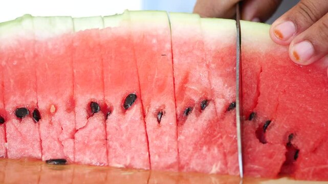 cutting water melon on a chopping board 
