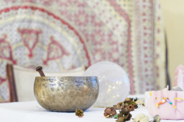 table of a fortune teller with tarot cards, candles, quartz stones, crystal ball on a white tablecloth.