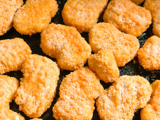 Preparation of nuggets. Battered pieces of meat in a pan. Fast food. Fast food - nuggets, junk food.