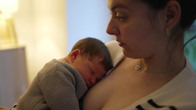 Mother yawning while holding her sleeping newborn, showcasing the exhaustion and dedication of parenthood. moment captures the reality of caring for a newborn with love and patience