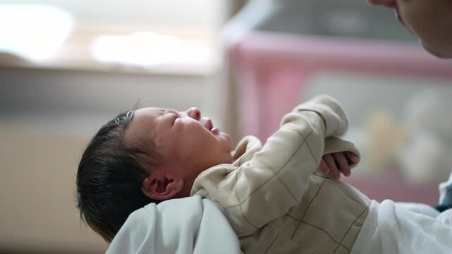 Close-up of a newborn baby crying, lying on a soft blanket in a peaceful home environment, capturing the raw emotions and moments of early infancy