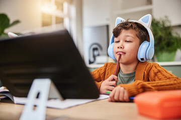 Boy, thinking and tablet in home for learning, virtual class and student headphones in notebook or...