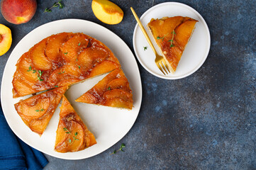Peach upside-down pound cake on a blue background. Fruit summer desset. Top view. Copy space