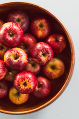 plenty of red apples in big wooden fruit bowl on kitchen countertop