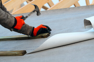 Construction Worker Installing Underlayment on Roof