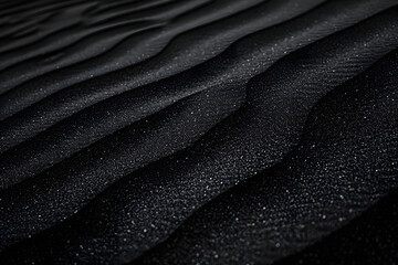 Fototapeta premium Black Sand dune. Black Sand beach macro photography. Background, texture, wave pattern of oceanic sand on the beach, black. Texture of beach sand. Black beach.
