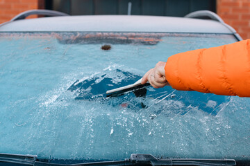 Person Scraping Ice Off Windshield of  Car in Winter