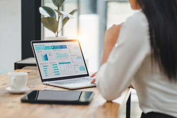 Professional data analyst using data visualizations dashboard on computer monitor for data business...