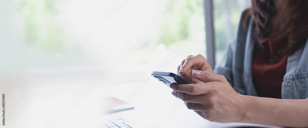 Wall mural business woman using mobile phone with laptop computer on office table. woman surfing the internet, 