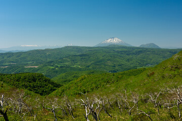 山の向こうに顔を出した冠雪した山