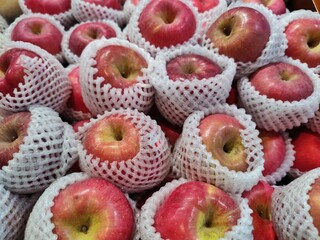 Vibrant red apples neatly arranged on a supermarket shelf. Crisp and fresh, these apples are a perfect symbol of health and natural goodness. Ideal for illustrating food, health, or market concepts.