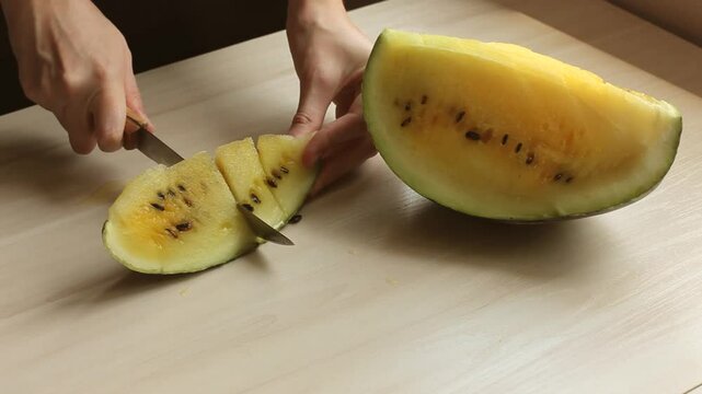 Slicing a juicy yellow watermelon.