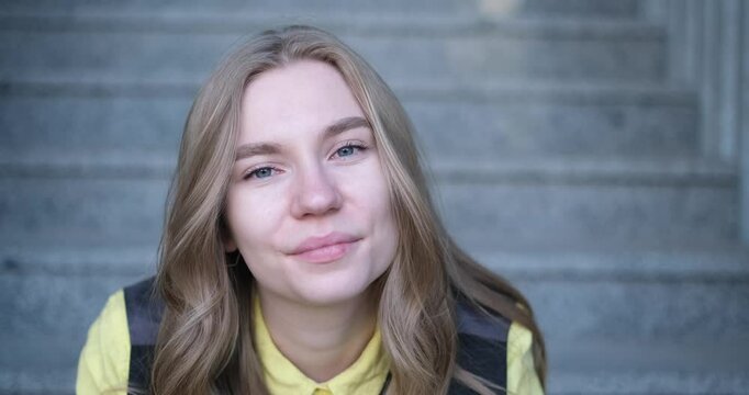 Beautiful blond female office worker on the background of office building . Positive emotions, wearing yellow shirt and jacket. video footage 4k