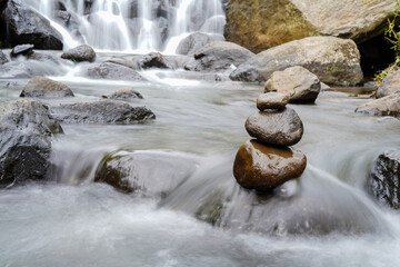 A Closeup of stacked rocks, Stack of zen stones in the background of a flowing river