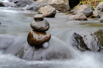 A Closeup of stacked rocks, Stack of zen stones in the background of a flowing river