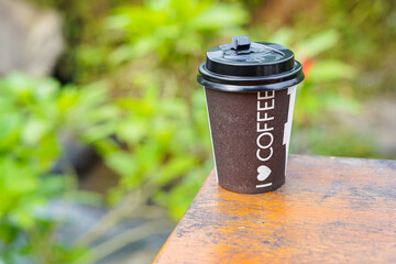 Paper cup of coffee on wooden table background