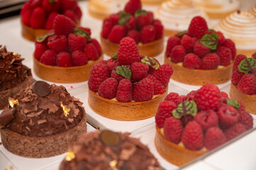 Various sweet cakes meringue, red fruits and berries framboise tartlets with cream