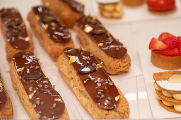 Various sweet cakes eclairs, meringue, red fruits and tartlets with cream
