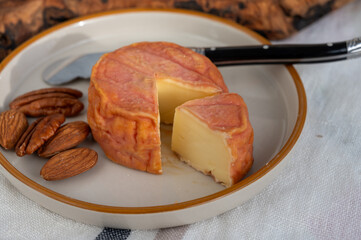 Rond des Vignes washed-rind cheese with.ivory-orange rind, strong nose with aromas, French soft cheese with orange rind