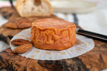 Rond des Vignes washed-rind cheese with.ivory-orange rind, strong nose with aromas, French soft cheese with orange rind