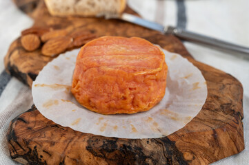 Rond des Vignes washed-rind cheese with.ivory-orange rind, strong nose with aromas, French soft cheese with orange rind