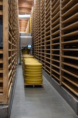 Aging rooms with shelves in cheese caves, central location for aging of wheels, rounds of Comte cheese from four months to several years made from raw cow milk, Jura, France