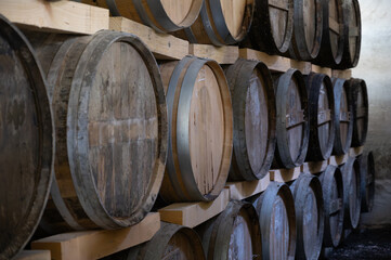 Aging process of cognac spirit in old dark French oak barrels in cellar in distillery house, Cognac white wine region, Charente, Segonzac, Grand Champagne, France