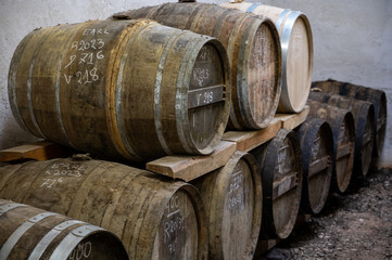 Aging process of cognac spirit in old dark French oak barrels in cellar in distillery house, Cognac white wine region, Charente, Segonzac, Grand Champagne, France
