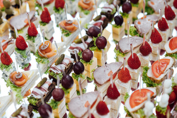 A large selection of various snacks for guests on a mirror surface. Buffet before an important event