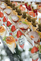 A large selection of various snacks for guests on a mirror surface. Buffet before an important event